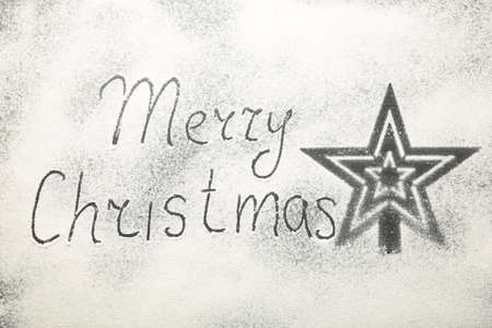 Christmas composition. Merry christmas text made with flour on black background, snow, december, top view, flat layの写真素材