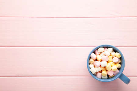Hot cocoa drink with a marshmallows on pink wooden background. Top view.の写真素材