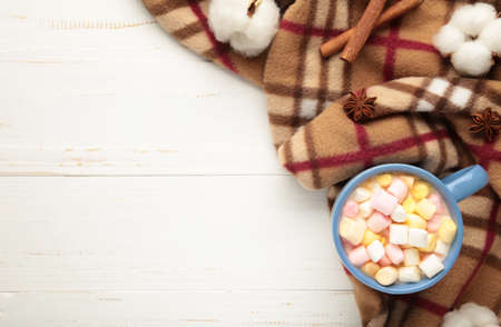 Cup of hot chocolate and marshmallows with plaid on gray wooden background. Top view.の写真素材