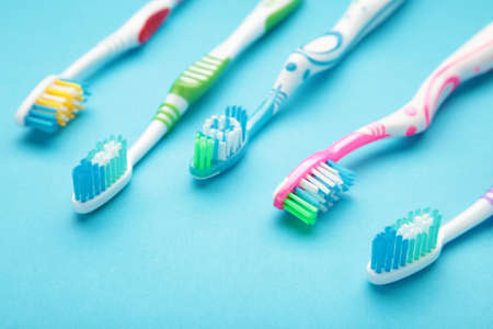 Toothbrushes on blue background with copy space. Top view