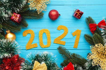 Happy New Year. Symbol from number 2021 and christmas decoration on blue wooden background. Top view.の写真素材