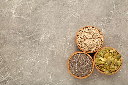 Pumpkin seeds, chia, sunflowers seeds in bowl on gray background. Top viewの写真素材