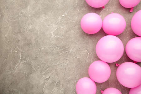 Pink balloons on gray background. Birthday, holiday concept. Top view.の写真素材