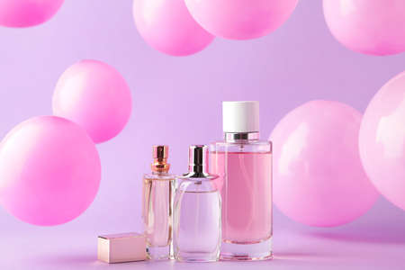 Perfume bottles with pink baloons on pink. Top viewの写真素材