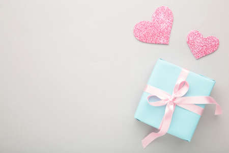 Valentines day background with pink hearts and gift box on gray background. Top view with copy space.の写真素材
