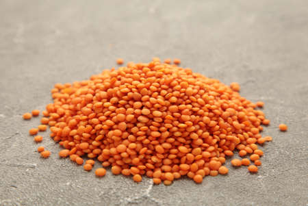 Red lentils on a gray concrete background. Close up.の写真素材