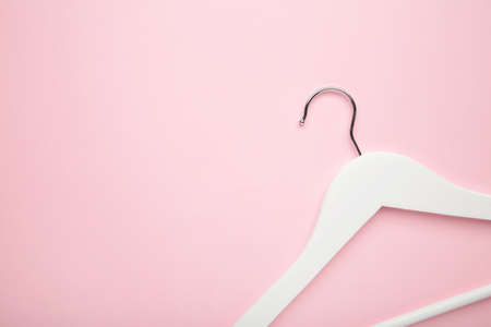 One wooden white hanger on pink background. Store concept, empty hanger.の写真素材
