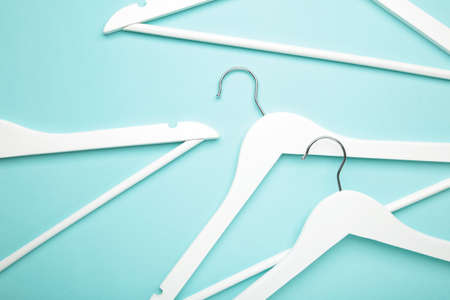 Many wooden white hangers on blue background. Store concept, empty hanger.