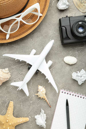 Airplane with traveler accessories on gray background. Travel concept