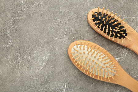 Set of comb and hairbrush on gray background. Top view