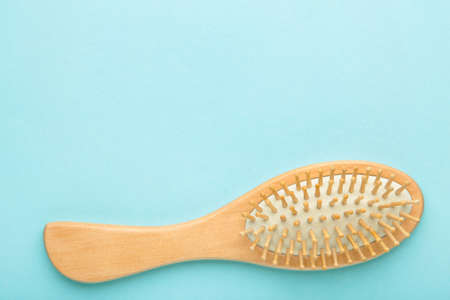 Wooden comb on blue background. Space for text, top viewの写真素材