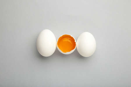 White eggs and egg yolk on the gray background. Top view.の写真素材