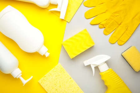 Cleaning Set. Yellow and white tools for cleaning. Cleaning agents, spray, rubber gloves on color background. Flat layの写真素材