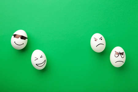 Funny Easter eggs with different emotions on his face on green background. Easter composition. Top viewの写真素材