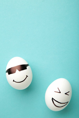Funny Easter eggs with different emotions on his face on blue background. Easter composition. Top...