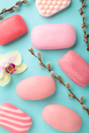 Different pink soaps with flowers. A lot of solid soap for hygiene and cleanliness on a blue...