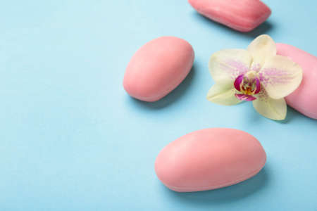 Different pink soaps with flowers. A lot of solid soap for hygiene and cleanliness on a blue...