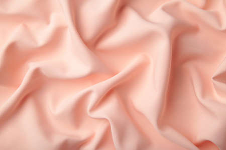 Peach silk background with drapery in the corner. Top viewの写真素材