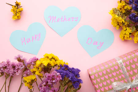Mother's day card with flowers and a present on pink background. Top viewの写真素材