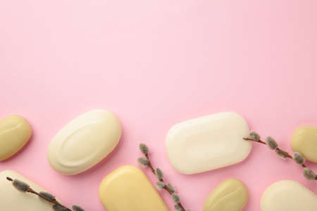 Different white soaps with flower. A lot of solid soap for hygiene and cleanliness on a pink...