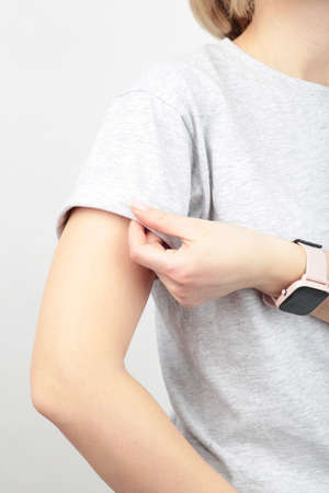 Young girl in gray T-shirt on a gray background. T-shirt design and people concept - close up. Top view.の写真素材