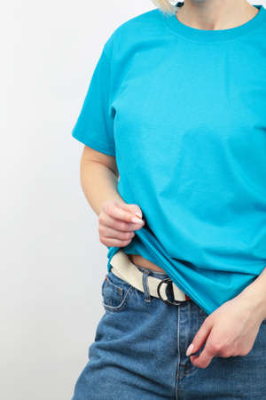 Young girl in blue T-shirt on a gray background. T-shirt design and people concept - close up. Top view.の写真素材