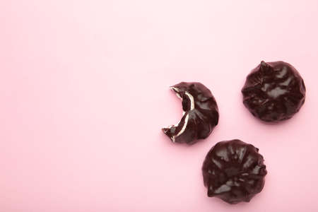 Chocolate covered marshmallows on pink background. Top view