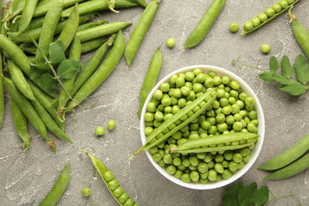 Green pea in bowl on gray background. Organic fresh vegetables. Top view.の写真素材