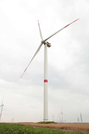 Windmills for electric power production on a cloudy day. Vertical photo