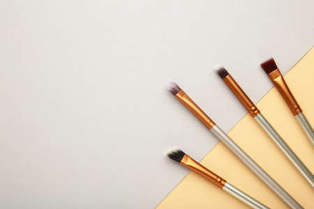 Various makeup brushes on gray and beige background with copy space. Top viewの写真素材