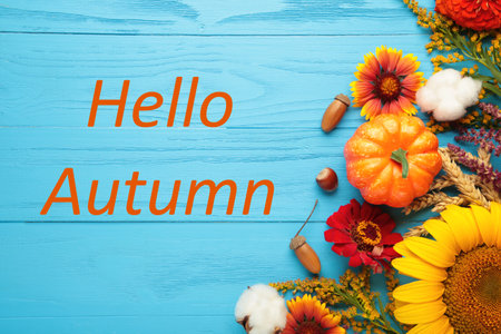 Hello Autumn message with different autumn flowers on blue background. Autumn compositionの写真素材