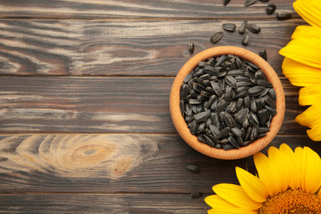 Sunflower with seeds in bowl on brown wooden background. top viewの写真素材