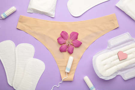 Women's panties with menstrual pads and tampons on pastel purple background. Top view. Concept of critical days, menstruation, feminine hygiene. Top viewの写真素材