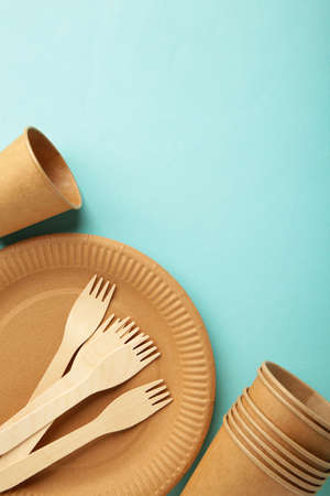Eco craft paper tableware. Paper cups, dishes, bag, fast food containers and wooden cutlery on blue background. Zero waste. Recycling concept. Copy spaceの写真素材