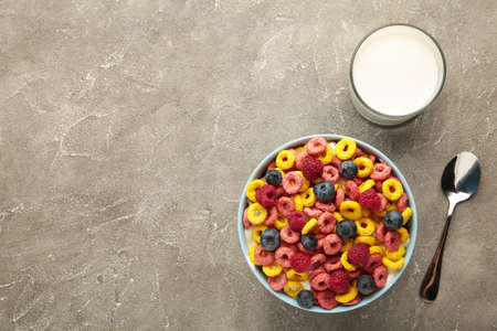 Breakfast with corn flakes, milk and berry on gray background. Top view. Vertical photo