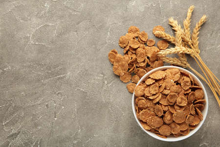 Crispy corn flakes on gray background. Top view