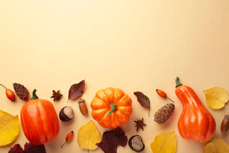 Creative autumn composition. Orange pumpkins with leaves on beige background. Top viewの写真素材