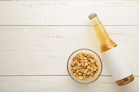 Glass of beer with peanuts on white wooden background. Top viewの写真素材
