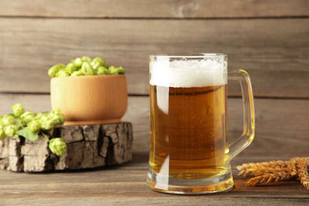 Glass of fresh beer with green hops and wheat on a gray background. Top viewの写真素材