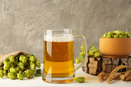 Glass of fresh beer with green hops and wheat on a gray background. Top viewの写真素材
