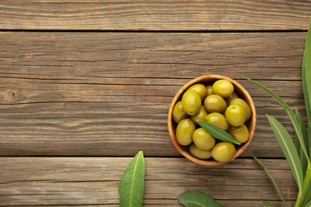 Fresh olives in bowl with leaves on gray background. Top viewの写真素材