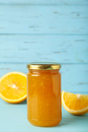 Jar of orange jam on blue background. Vertical photo. Top viewの写真素材