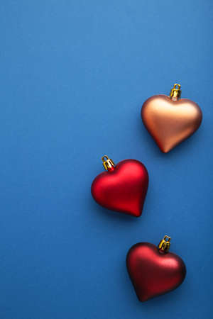 Christmas background. Red toys heart on blue background. Greeting card. New year concept. Top viewの写真素材