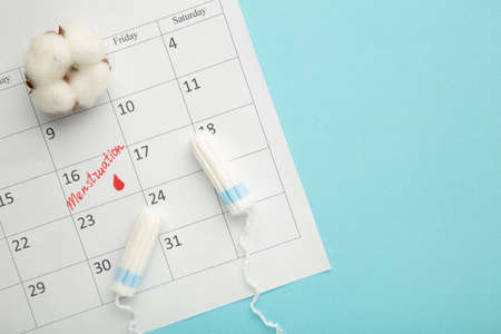 Menstruation calendar with cotton tampons and pads. Woman critical days, woman hygiene protection. Top viewの写真素材