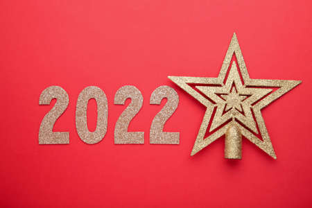 Inscription 2022 with christmas star on red background. Happy New Year. Flat lay. Top view.の写真素材
