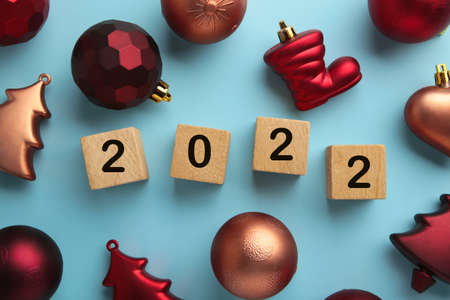Christmas background with fir trees, fir cones and Christmas decorations and numerals 2022. New Year concept on blue. Top viewの写真素材