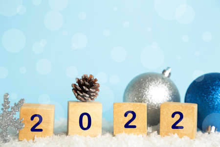 Christmas background with Christmas balls and numerals 2022. New Year concept on blue. Top view