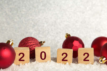 Christmas background with Christmas balls and numerals 2022. New Year concept on white. Top view