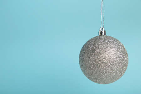 Glittering silver Christmas ball on blue background. Top viewの写真素材