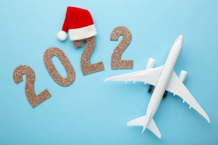 Christmas background with airplane and inscription 2022 on blue background. Christmas holiday